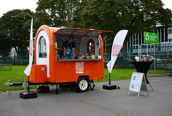 orange trailer pod with employee inside posing for picture